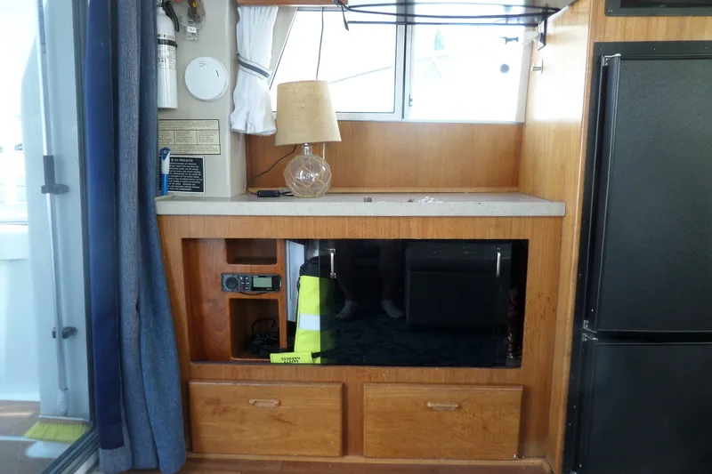 Slide: The Image of Interior of a 1997 Mainship 350 Trawler featuring a wooden cabinet and appliances. - 35