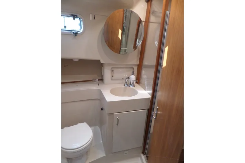 Slide: The Image of Bathroom interior of 1997 Mainship 350 Trawler with sink, toilet, and mirror. - 26