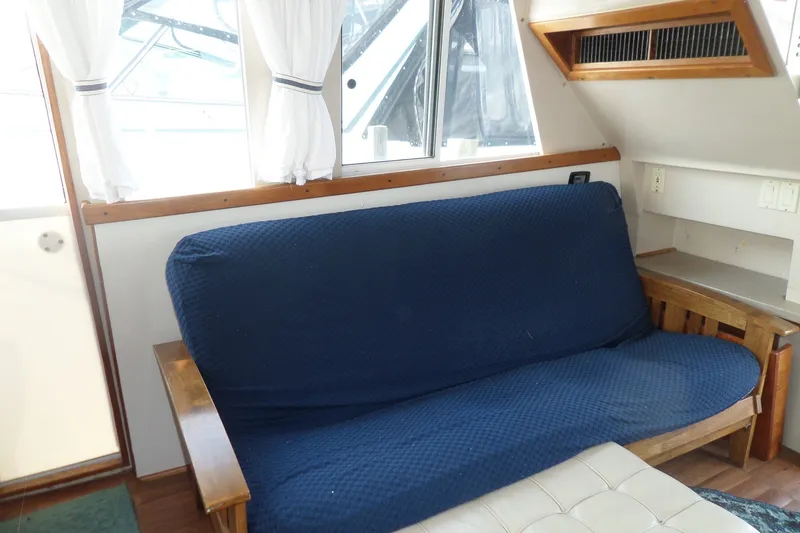 Slide: The Image of Interior of 1997 Mainship 350 Trawler with blue sofa and white curtains. - 49