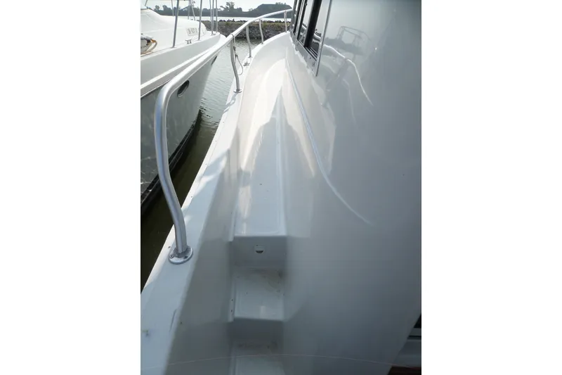 Slide: The Image of 1997 Mainship 350 Trawler side deck with railing, docked beside another boat. - 91