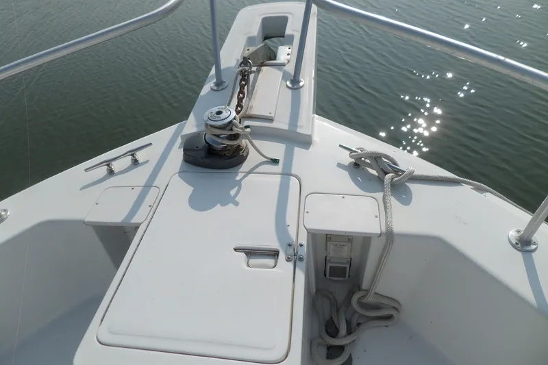 Slide: The Image of Bow of 1997 Mainship 350 Trawler with anchor chain and rope, on calm water. - 52