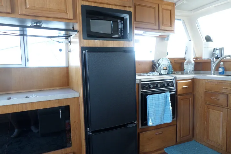 Slide: The Image of Interior of 1997 Mainship 350 Trawler kitchen with wooden cabinets and modern appliances. - 36