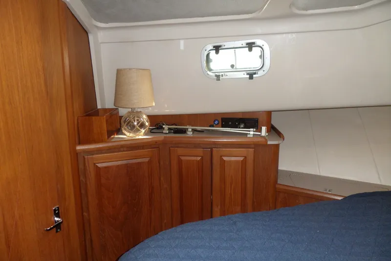 Slide: The Image of Interior cabin of 1997 Mainship 350 Trawler with wooden cabinetry and a small window. - 20