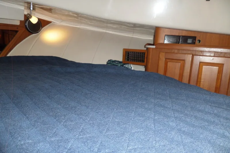 Slide: The Image of Cozy cabin interior of 1997 Mainship 350 Trawler with blue bedding and wooden cabinetry. - 22