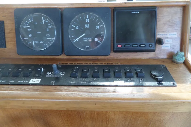 Slide: The Image of 1997 Mainship 350 Trawler dashboard with gauges, switches, and Garmin display. - 43