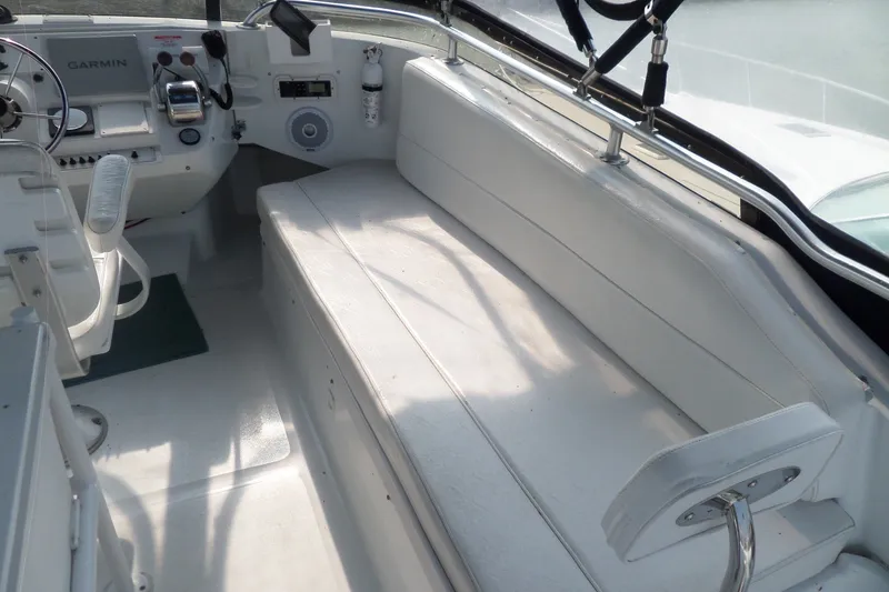 Slide: The Image of 1997 Mainship 350 Trawler cockpit with white seating and navigation equipment. - 89