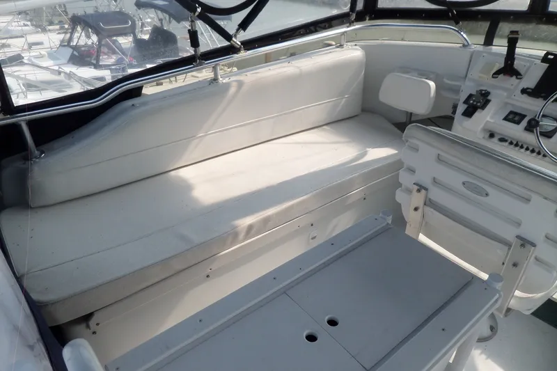 Slide: The Image of 1997 Mainship 350 Trawler cockpit with white seating and control panel. - 87