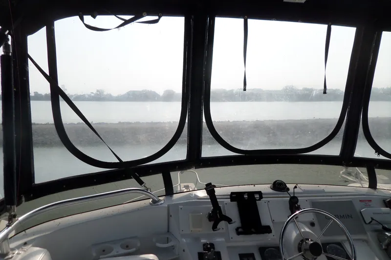 Slide: The Image of Interior view from the helm of a 1997 Mainship 350 Trawler, overlooking calm waters. - 78