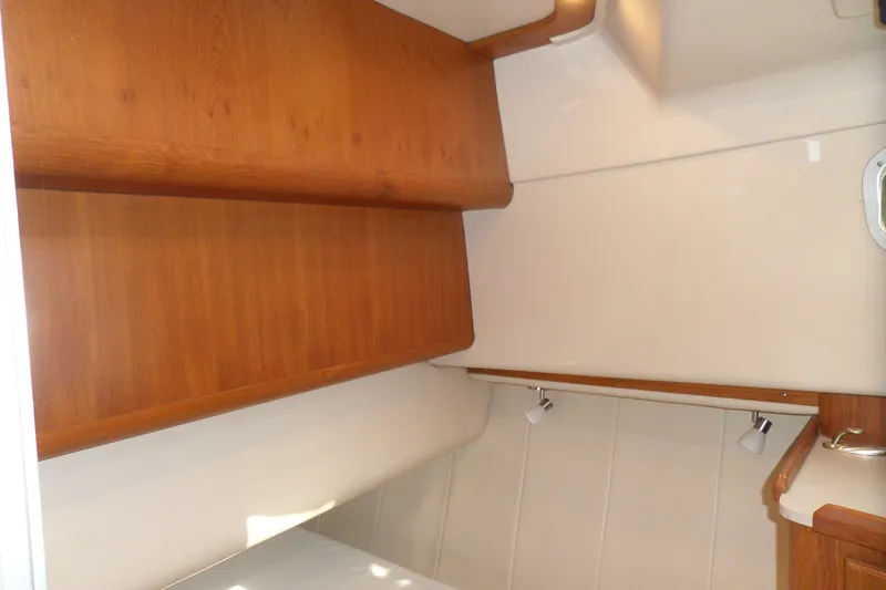 Slide: The Image of 1997 Mainship 350 Trawler interior with wooden cabinetry and modern lighting. - 18