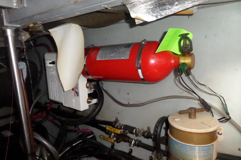 Slide: The Image of Engine room of 1997 Mainship 350 Trawler with fire extinguisher and wiring. - 13