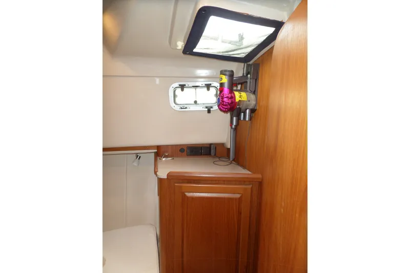 Slide: The Image of Interior of 1997 Mainship 350 Trawler with wooden cabinetry and mounted vacuum cleaner. - 17