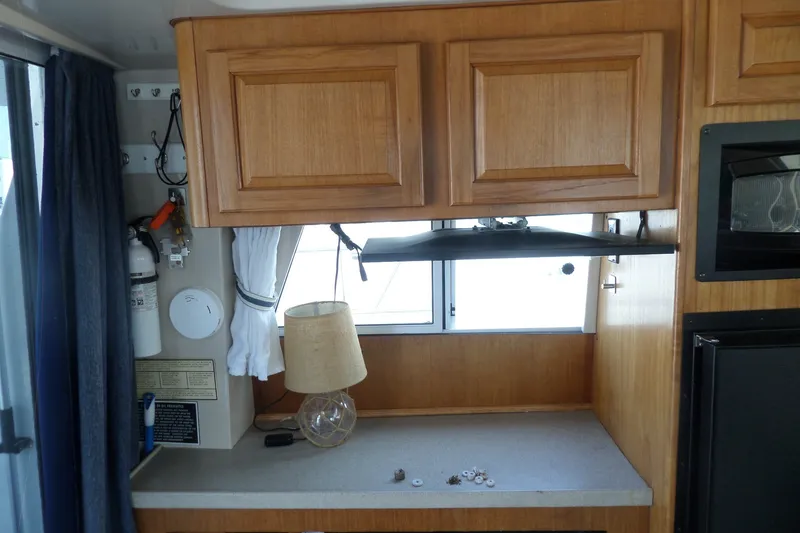 Slide: The Image of Interior of 1997 Mainship 350 Trawler with wooden cabinets and countertop. - 34