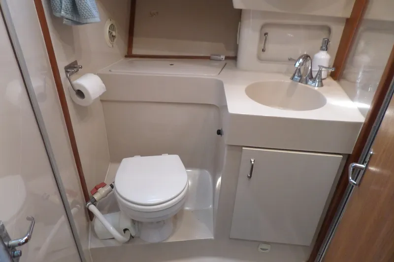 Slide: The Image of Bathroom interior of a 1997 Mainship 350 Trawler, featuring a toilet and sink. - 28