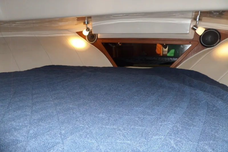 Slide: The Image of Cozy cabin interior of 1997 Mainship 350 Trawler with blue bedding and warm lighting. - 21