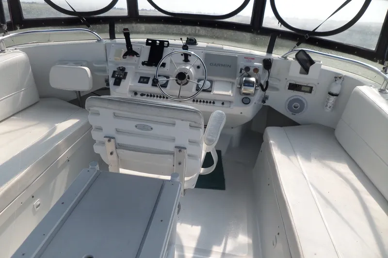 Slide: The Image of 1997 Mainship 350 Trawler helm with steering wheel, navigation equipment, and seating. - 88