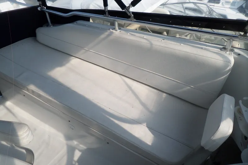 Slide: The Image of 1997 Mainship 350 Trawler interior seating area with white cushions and metal railing. - 76