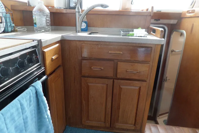 Slide: The Image of 1997 Mainship 350 Trawler kitchen with wooden cabinets and stainless steel sink. - 39