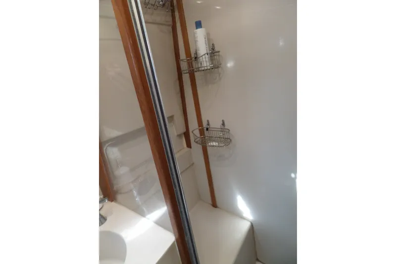 Slide: The Image of Bathroom interior of 1997 Mainship 350 Trawler with shower and storage shelves. - 31