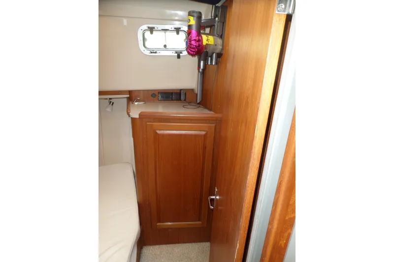 Slide: The Image of Interior of 1997 Mainship 350 Trawler with wooden cabinetry and small window. - 16