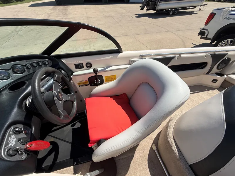 Slide: The Image of The image shows a boat cockpit with a gray seat and a red cushion. - 14