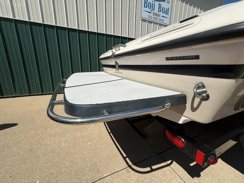 Slide: The Image of The image shows the rear of a 1999 Supra Legacy boat with a swim platform. - 4