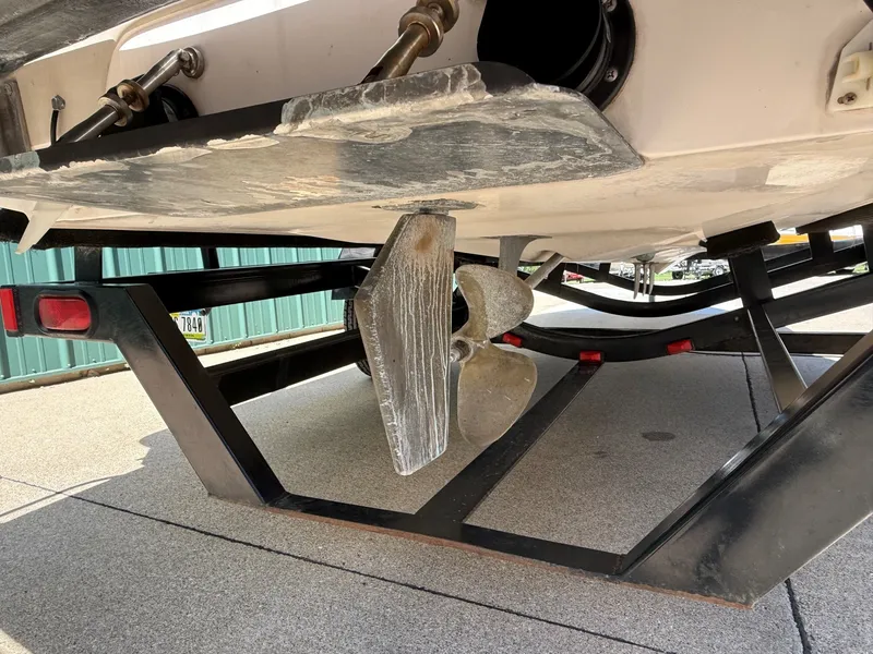 Slide: The Image of The underside of a boat shows the propeller and rudder resting on a trailer. - 7
