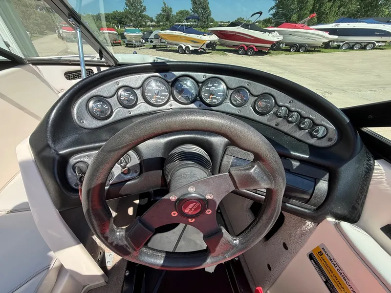 Slide: The Image of Dashboard of a 1999 Supra Legacy boat with steering wheel and gauges. - 16