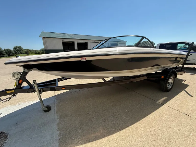 Slide: The Image of A black and white motorboat, 1999 Supra Legacy model, is on a trailer. - 2
