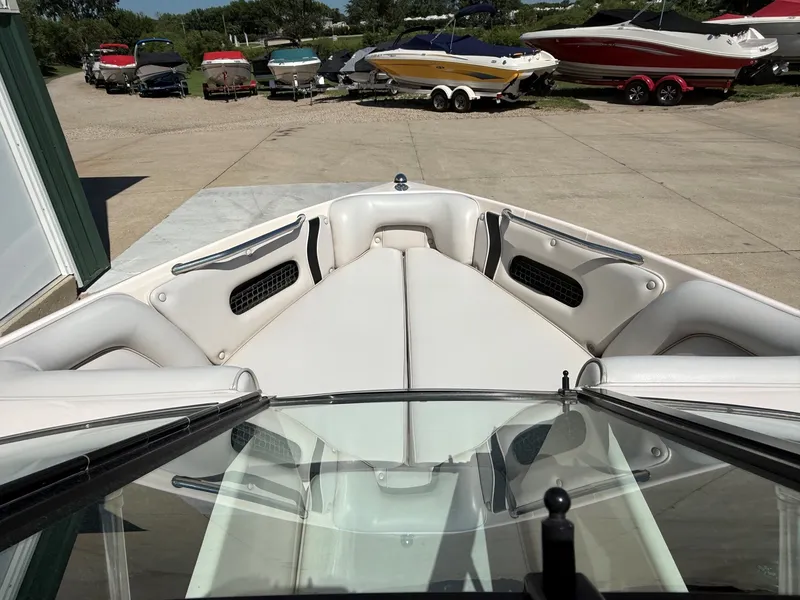 Slide: The Image of The image shows the bow area of a white boat with cushioned seats and several boats in the background. - 10