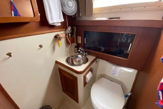 Slide: The Image of 1997 Fortier 33 boat bathroom with sink, toilet, and wooden cabinetry. - 10