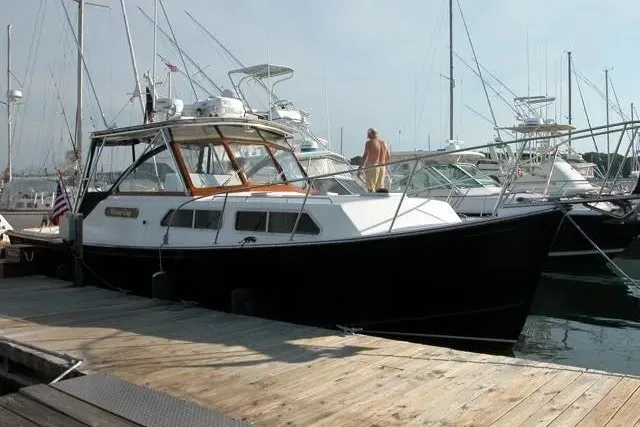 Slide: The Image of 1997 Fortier 33 boat docked at a marina with other vessels. - 3
