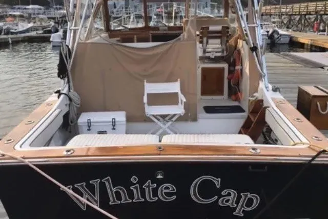 Slide: The Image of Fortier 33 boat named "White Cap" docked at a marina, rear view, 1997 model. - 4