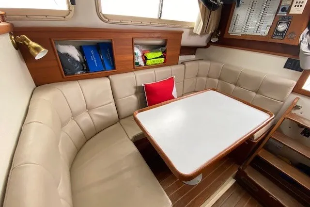 Slide: The Image of Cozy interior of a 1997 Fortier 33 boat with cushioned seating and a dining table. - 15