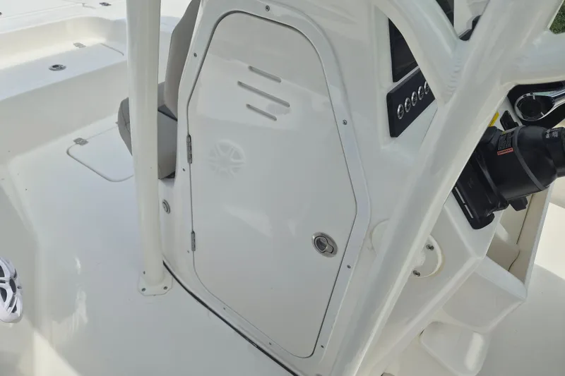 Slide: The Image of 2026 Key West 230 Bay Reef boat interior, featuring a sleek white console and storage compartment. - 16