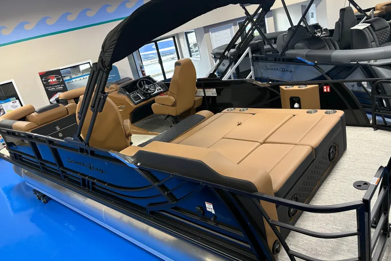 Slide: The Image of 2027 South Bay 525UL pontoon boat with tan seating and modern interior design. - 2