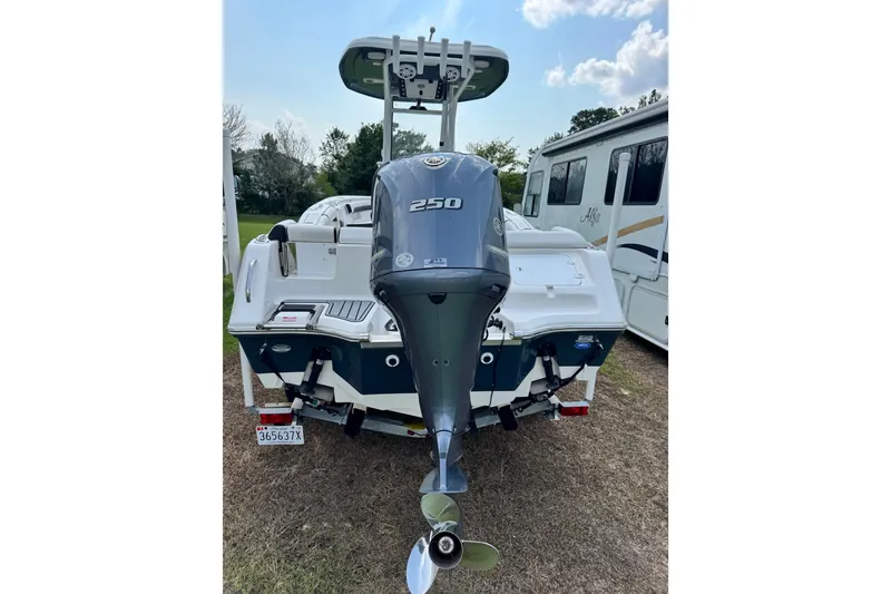 Slide: The Image of 2022 Tidewater 232 LXF boat with powerful 250 horsepower outboard motor, parked outdoors. - 2