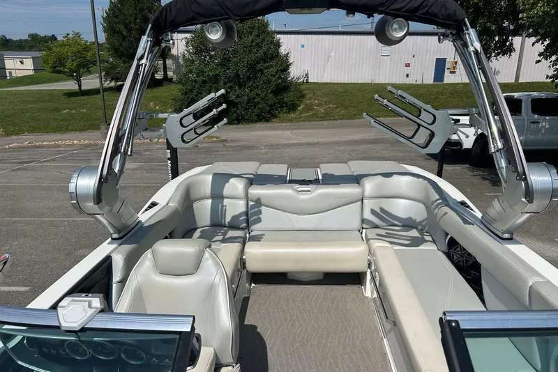 Slide: The Image of 2017 MasterCraft XT23 boat interior with seating and wakeboard racks in a parking lot. - 9