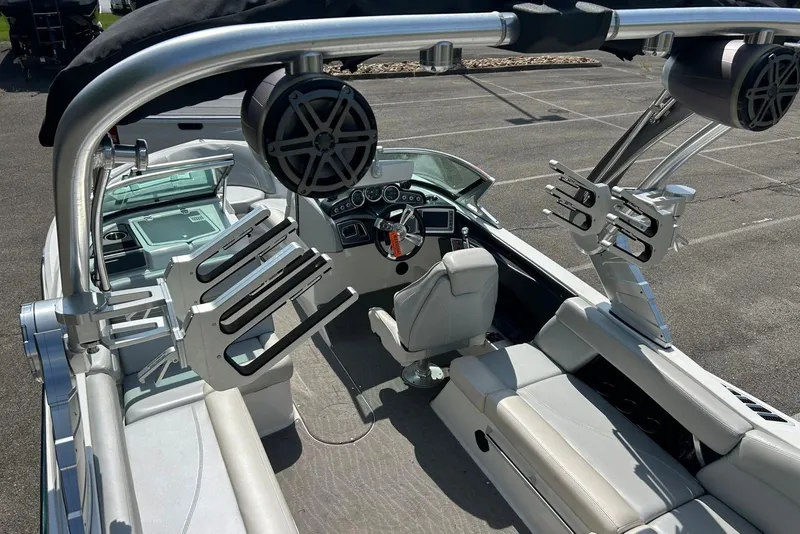 Slide: The Image of 2017 MasterCraft XT23 boat interior with sleek seating, advanced dashboard, and wakeboard racks. - 8