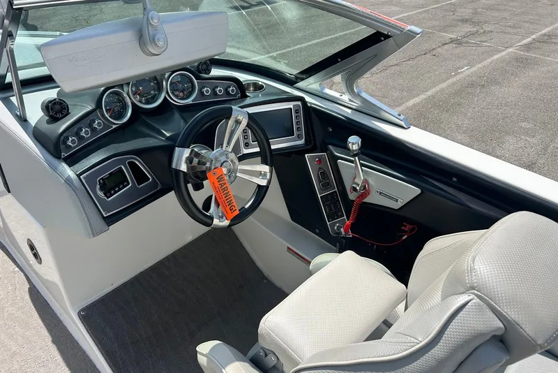 Slide: The Image of 2017 MasterCraft XT23 boat cockpit with steering wheel, gauges, and control panel. - 7