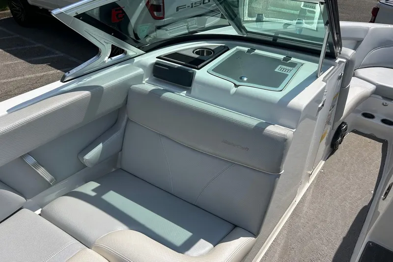Slide: The Image of 2017 MasterCraft XT23 boat interior with white seating and storage compartment. - 10