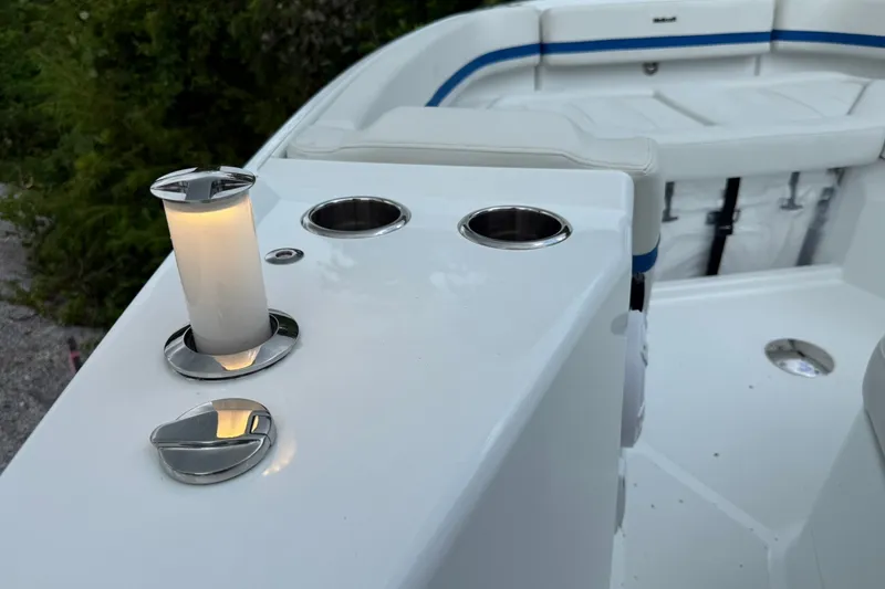 Slide: The Image of The image shows the deck of a 2026 Wellcraft 28 T-Top boat with cup holders and upholstery. - 10