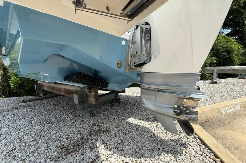 Slide: The Image of The image shows the stern of a 2026 Wellcraft 28 T-Top boat with an outboard motor. - 4