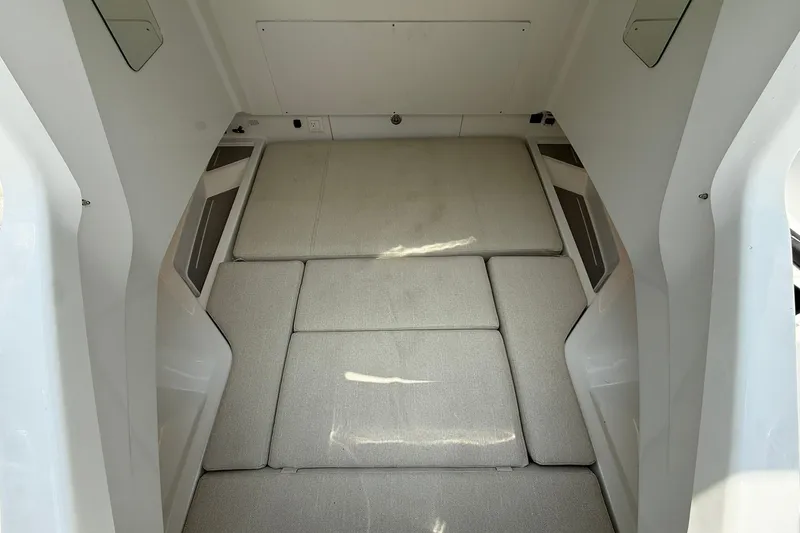 Slide: The Image of Interior view of a modern boat cabin with cushioned sleeping area and white walls. - 11