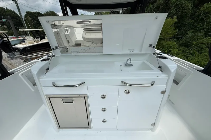 Slide: The Image of The 2026 Wellcraft 28 T-Top features a modern outdoor kitchen with a sink and storage. - 21