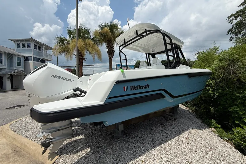 Slide: The Image of A 2026 Wellcraft 28 T-Top boat on gravel. It features a white hull and a T-top. - 3