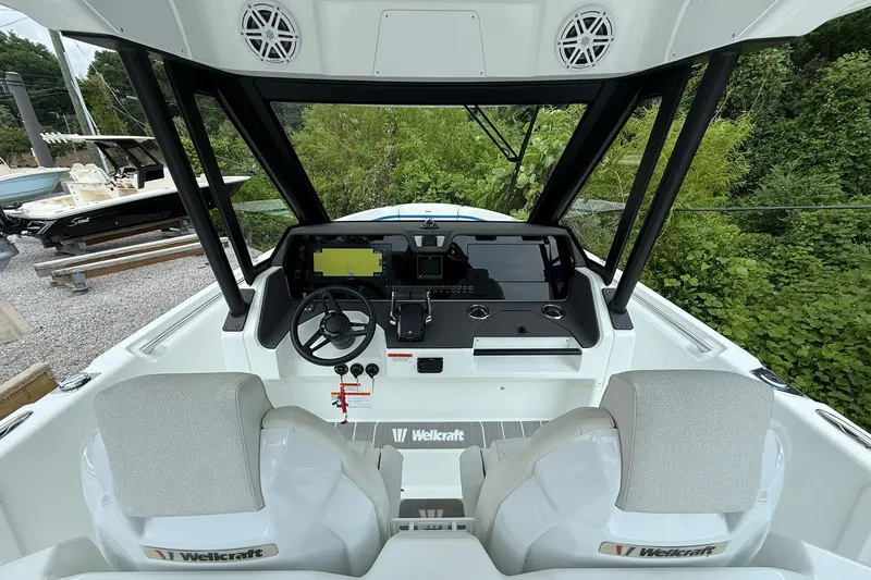 Slide: The Image of The image shows the cockpit of a 2026 Wellcraft 28 T-Top boat with two seats and modern electronics. - 16
