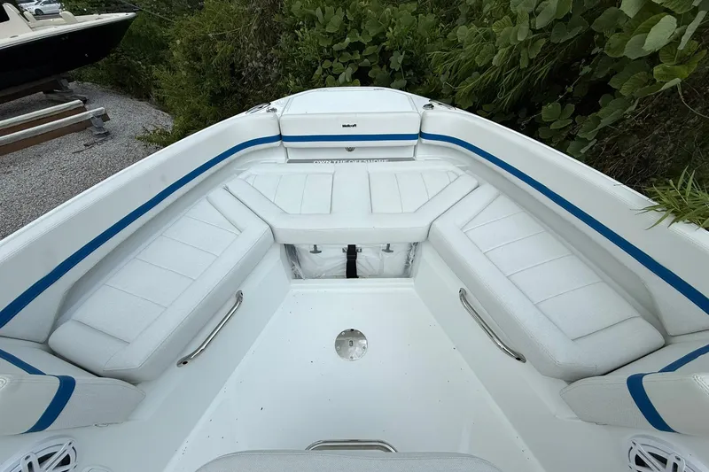 Slide: The Image of The image shows the bow of a Wellcraft 28 T-Top boat with white cushioned seats and blue accents. - 8