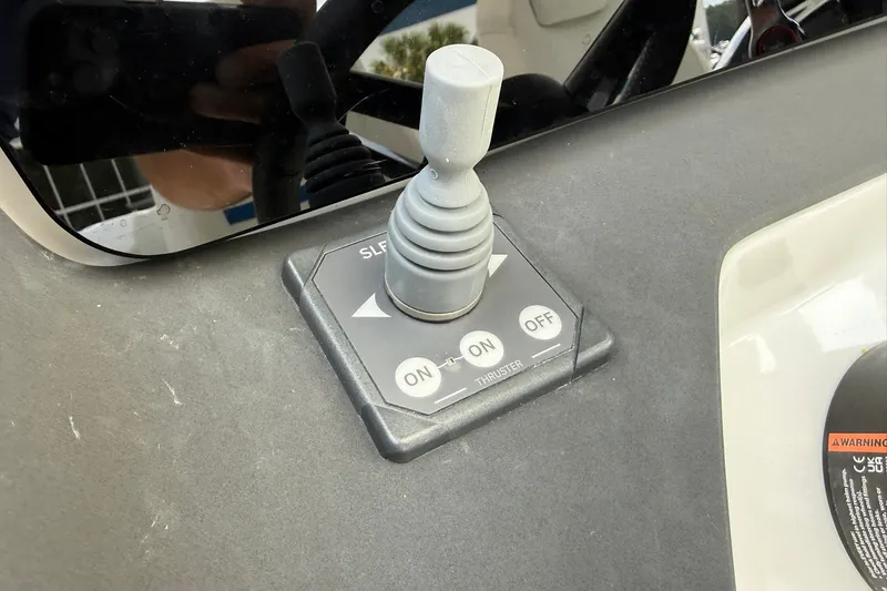 Slide: The Image of Close-up of a joystick on a boat, surrounded by controls and a warning label. - 18