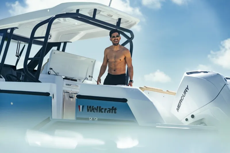 Slide: The Image of Man enjoying a sunny day on a 2026 Wellcraft 28 T-Top boat. - 6