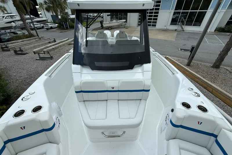 Slide: The Image of The image shows the cockpit of a 2026 Wellcraft 28 T-Top boat with white seating and blue accents. - 9